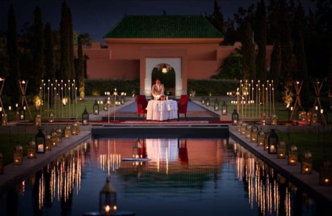 Private dinner by a reflection pool in Marrakech, lanterns and candles